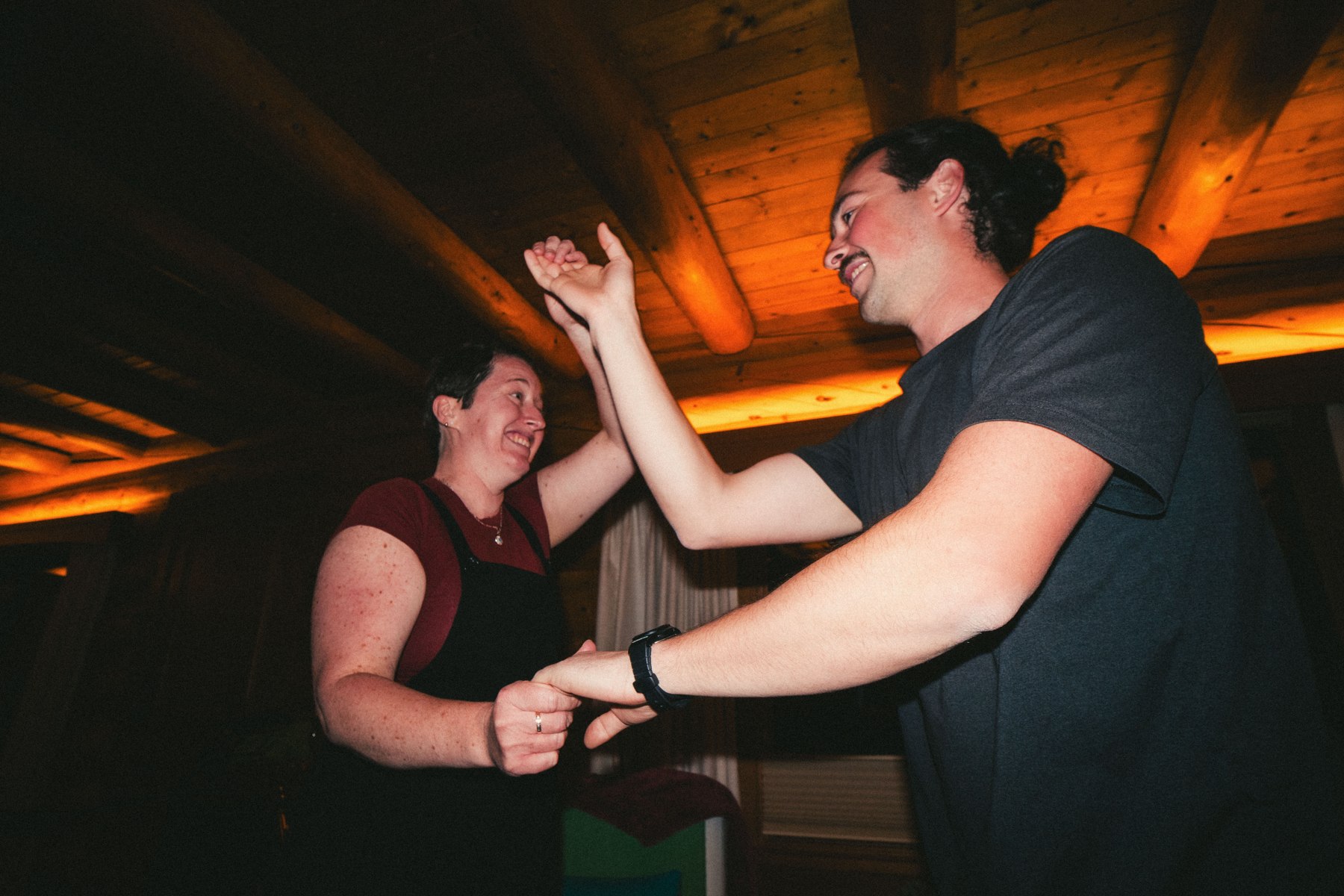 Two people dancing together under a wooden ceiling
