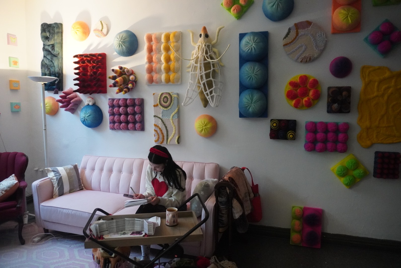 An artist surrounded by colourful textile work in a studio
