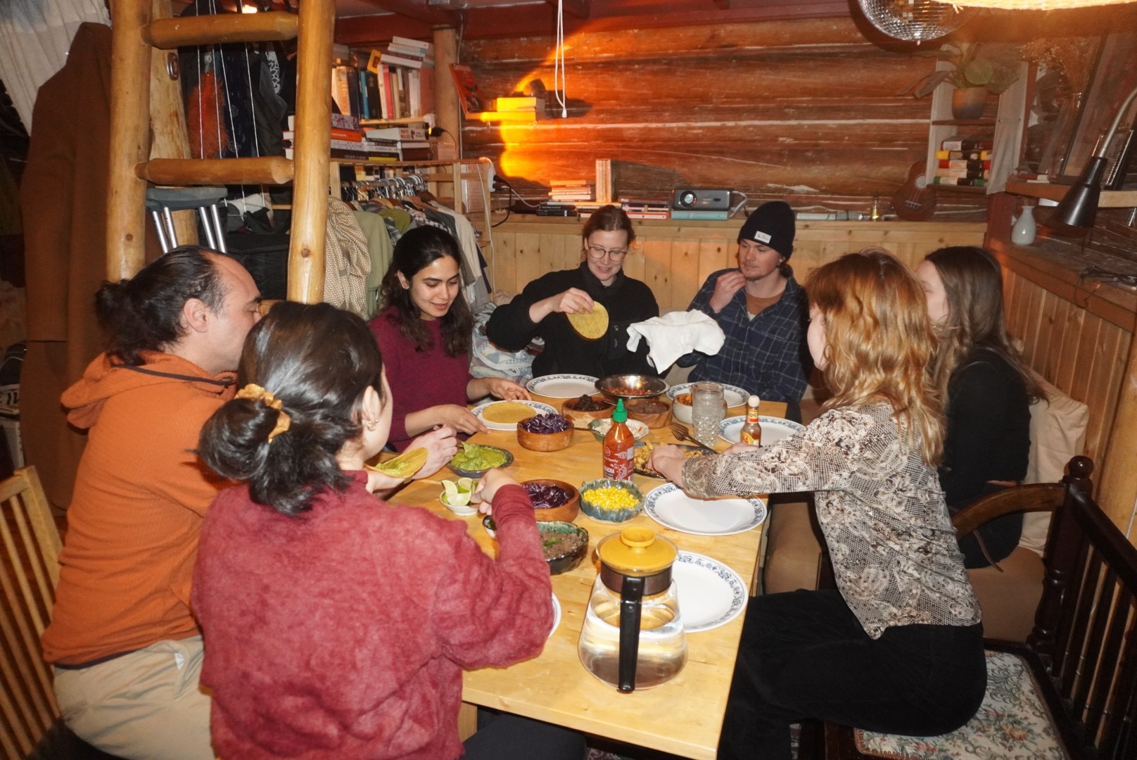 Friends sharing a meal around a cabin table