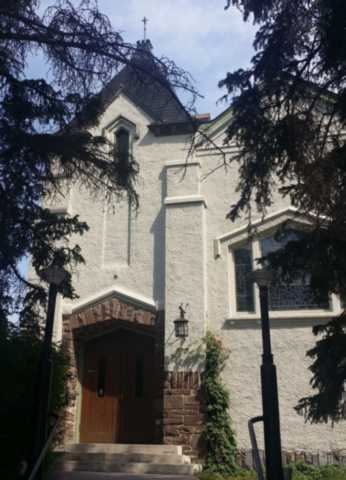 The church exterior and entrance, framed by trees