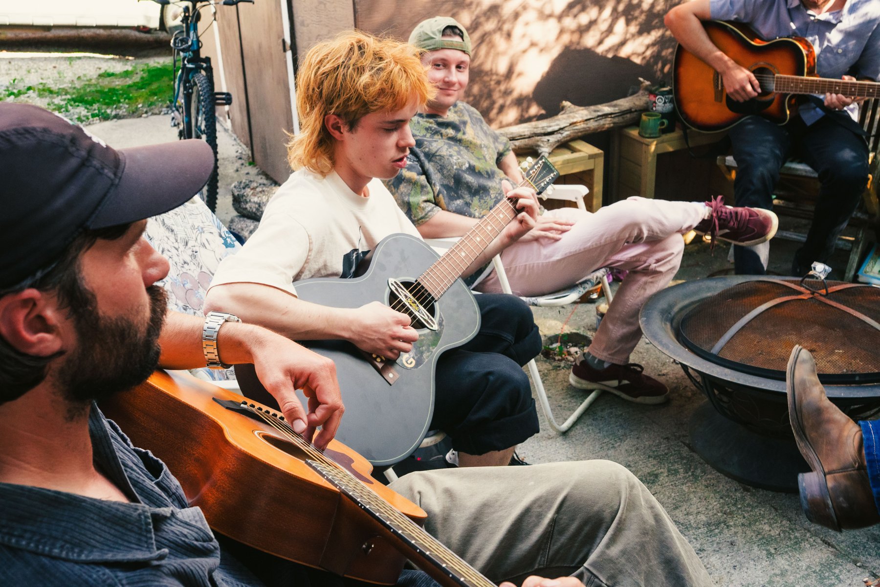 Musicians playing guitars together outdoors