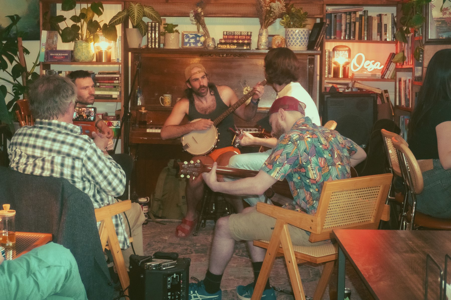 Musicians gathered around a piano playing banjo and guitars